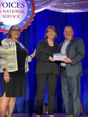Jerise Terrell, Voices for National Service Steering Committee, and AnnMaura Connolly, President of Voices for National Service, present Judd Jeansonne with the Stoneman Brown Advocate of the Year award.